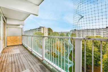 Tırabzanların yanında örgü olan uzun dar bir balkon.