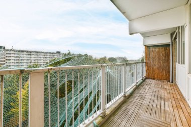 Tırabzanların yanında örgü olan uzun dar bir balkon.