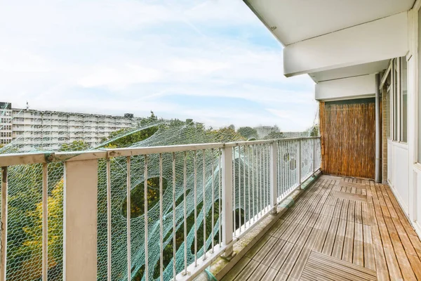 Tırabzanların yanında örgü olan uzun dar bir balkon.