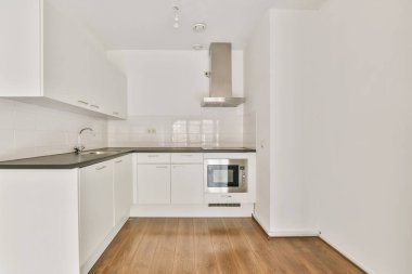 Beyaz mutfak ünitesi olan lüks küçük bir mutfak.