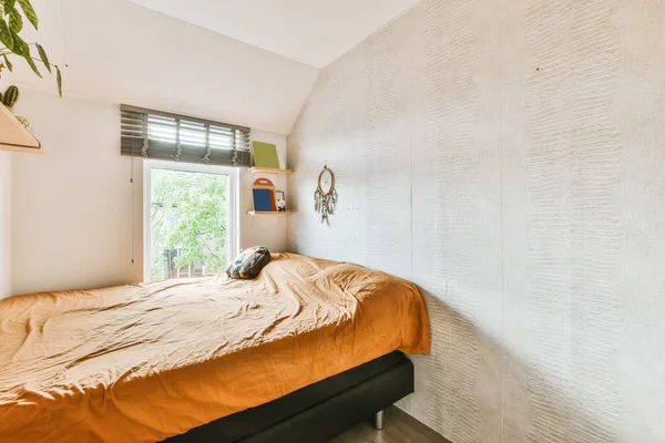 Wspaniała mała sypialnia z pomarańczową narzutą — Zdjęcie stockowe