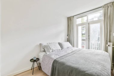 Gri yatak örtülü, üstün yatak odası tasarımı.