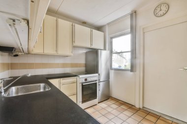 Döşemeleri döşemeli büyük, rahat bir mutfak.