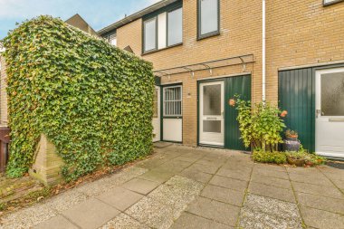 Yeşillikleri olan iki katlı bir ev.