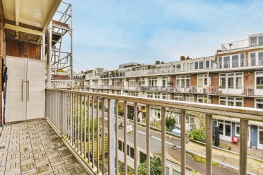 Sokağa bakan binalarla dolu uzun bir balkon.