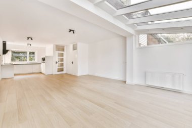 Güzel döşenmiş parkesi olan geniş bir odanın içi.