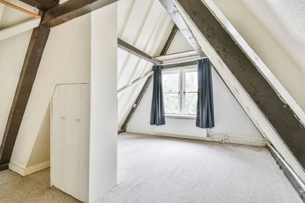 Attic area of the house with a miniature window — Stock Photo, Image