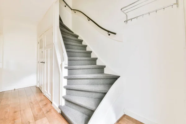 Красивая винтовая лестница с серым ковром — стоковое фото