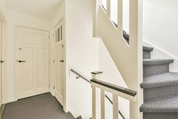 Красивая винтовая лестница с серым ковром — стоковое фото