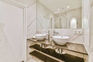 İki yuvarlak lavabosu olan akıl almaz bir banyo.