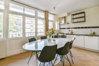 Oval masa ve siyah sandalyeli akıl almaz bir yemek odası.