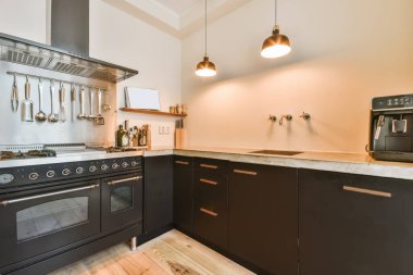 Tamamen siyah mobilyalı rahat bir mutfak.