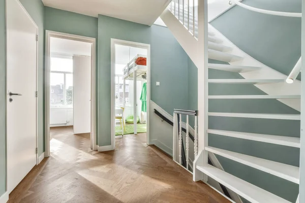 Yumuşak mavi duvarları ve sarmal merdivenleri olan şık bir salon. — Stok fotoğraf