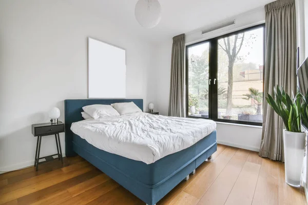 Znakomita sypialnia z niebieskim łóżkiem i pokryte miękką narzutą — Zdjęcie stockowe