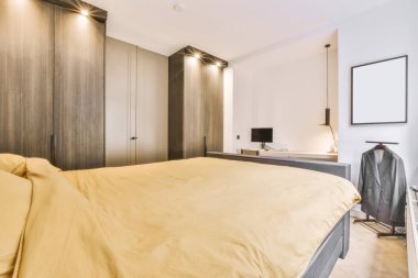 Sarı yatak örtüsüyle kaplı yumuşak bir yatak.