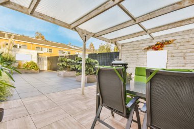 Siyah masası ve sandalyeleri olan şık bir evin avlusu.