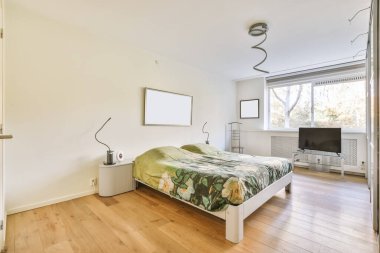 Alışılmadık bir avizesi olan rahat bir yatak odası.