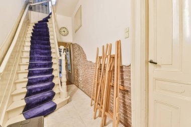 Geniş apartman koridorundaki ahşap merdiven.