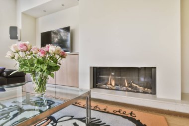 Yanan şöminesi olan rahat bir oturma odası.