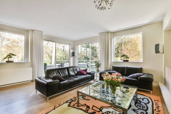 Comfortable living room with black leather sofa — Fotografia de Stock