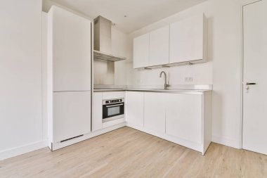 Beyaz mutfak üniteli hafif, küçük bir mutfak.