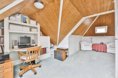 Cozy furnished attic with a high wooden ceiling