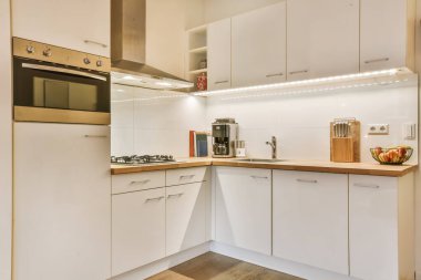 Beyaz mutfak ünitesi olan sevimli küçük bir mutfak.