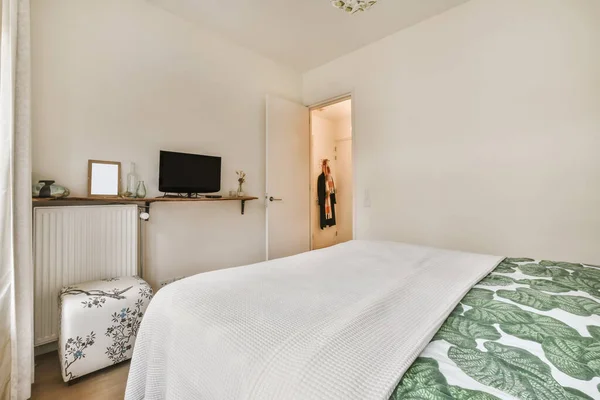 Adorável quarto com uma cama coberta com uma folha — Fotografia de Stock