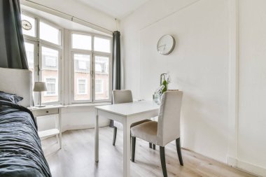 Gri yatak örtüsü ve masası olan rahat çift kişilik yatak odası.