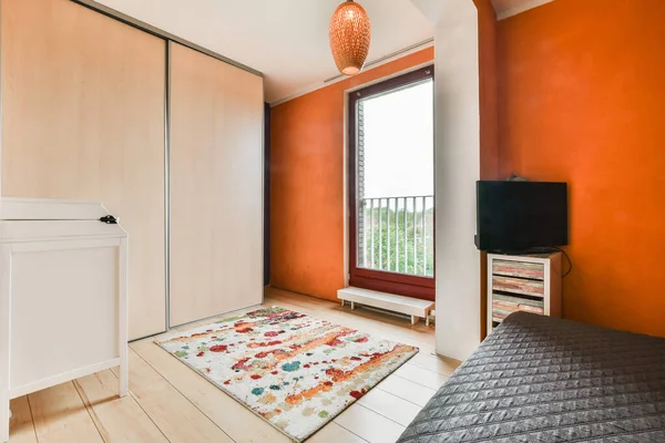 Gyönyörű hálószoba narancssárga falakkal — Stock Fotó