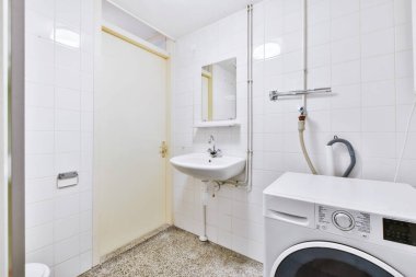 Çamaşır makinesi olan minimalist banyo.