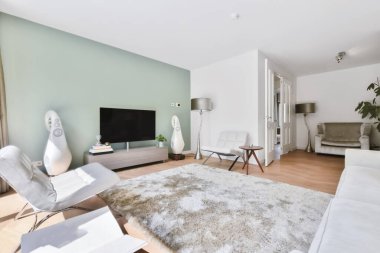 Kar beyazı kanepesi ve koltukları olan şık bir oturma odası.