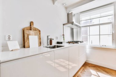 Kar beyazı mutfak takımı olan şık bir mutfak.