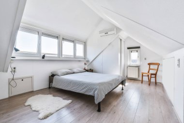 Yumuşak yataklı ve komodinli göz kamaştırıcı bir yatak odası.