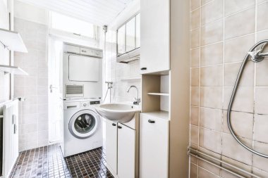 Siyah döşemeleri olan güzel bir banyo alanı.