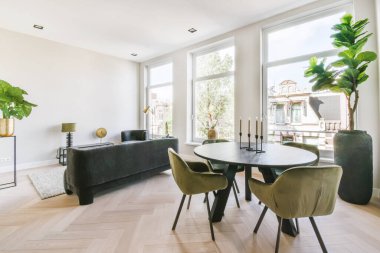 Yuvarlak masa ve kadife sandalyeli şık bir yemek odası.