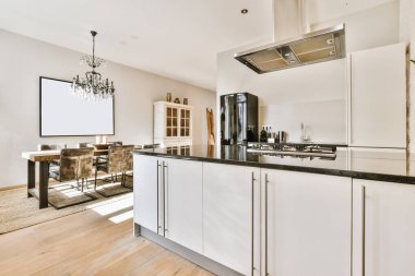 Beyaz mutfak ve mermer tezgahı olan rahat bir mutfak.