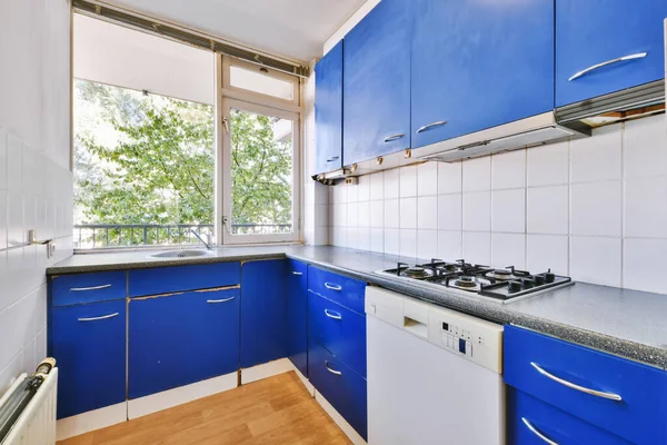 Современная кухня с синим кухонным набором — стоковое фото