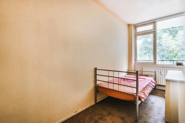Kırmızı yatak örtüsüyle kaplı tek yataklı modern bir yatak odası. — Stok fotoğraf