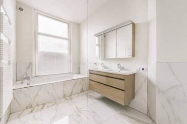 Mermer duvarları ve zemini olan inanılmaz bir banyo tasarımı.