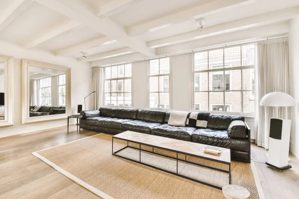 Fantastiskt vardagsrum med lång svart soffa — Stockfoto