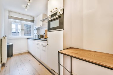 Siyah tezgahı olan şık ve uzun bir mutfak.