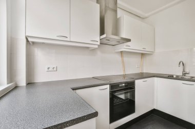 Siyah tezgahlı küçük bir mutfağın büyüleyici tasarımı.