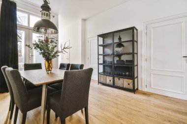 Masası ve siyah peluş sandalyeleri olan harika bir yemek salonu.