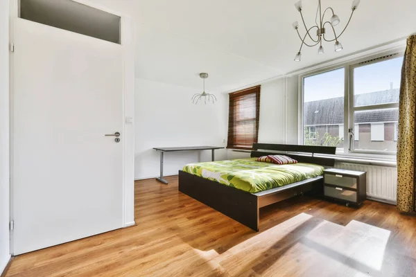 Ett fascinerande sovrum med en säng täckt med ett grönt överkast — Stockfoto