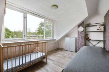 Yatağın üzerinde gri bir yatak örtüsü olan yatak odası.