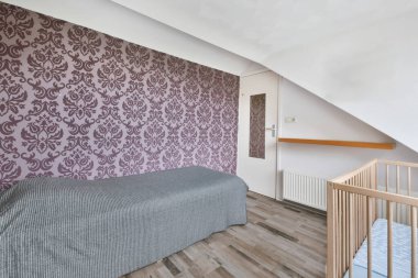 Yatağın üzerinde gri bir yatak örtüsü olan yatak odası.