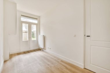 Büyük ahşap pencereli parlak bir oda.