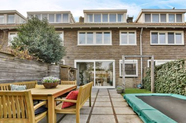 Trambolin ve yemek masası olan küçük bir ev.