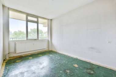 Yeşil zemini olan boş ve parlak bir oda.